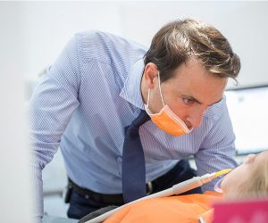 Doctor evaluando daños por habitos diarios que perjudican los dientes en niños